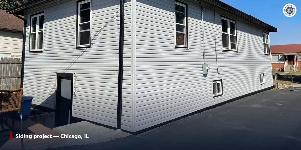 Two-story house with white vinyl siding and several double-hung windows on two sides, after a siding project in Chicago