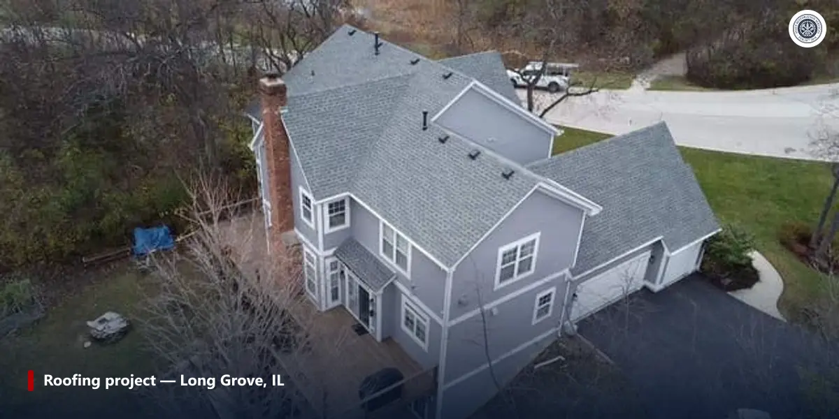 Aerial view of a gray two-story house with an attached one-story garage and a gray shingle roof in Long Grove, Illinois