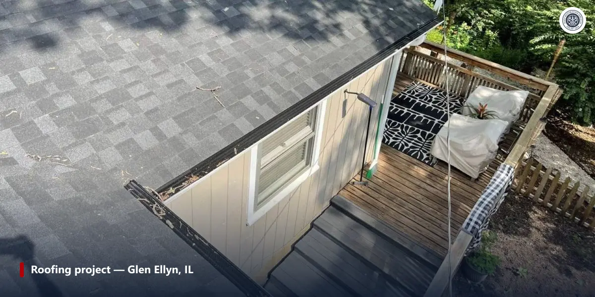 Completed asphalt shingle roof and gutter above a rear deck on a Chicago-area home