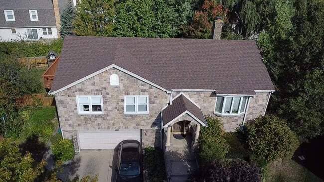 Close-up view of a newly installed residential asphalt shingle roof featuring clean lines, precise ridge caps, and professional installation standards. The high-quality roofing system provides exceptional durability and modern curb appeal.