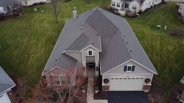 Evening shot of light shingles installed by State Restoration Services, captured after sunset, highlighting the soft glow and detailed workmanship.