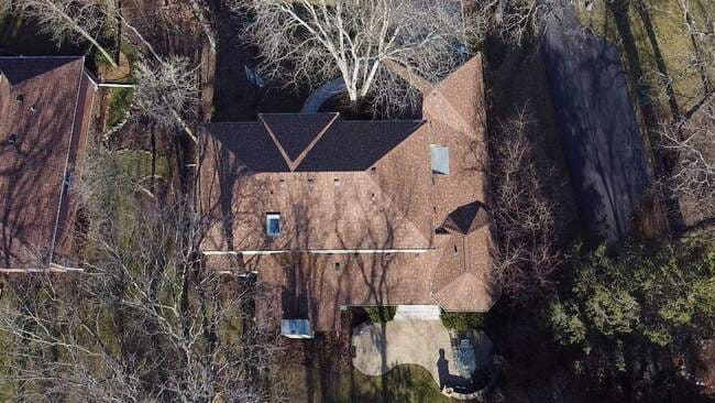 Rooftop perspective of a newly installed residential asphalt shingle roof featuring clean lines, precise ridge caps, and professional flashing work. The high-quality roofing system provides exceptional durability and modern curb appeal.