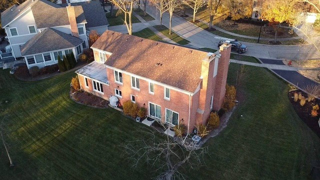 Aerial view of the Orange Mansion roof installed by State Restoration Services, highlighting the bold color choice and meticulous installation.