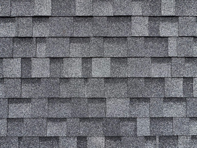  New Roof Installation: Selling Description This stunning new roof installation features high-quality architectural shingles in a rich, multi-tonal gray. The durable, weather-resistant materials provide superior protection and enhance your home's curb appeal. A perfect blend of function and style, this roof will stand the test of time, increasing your property value and giving you peace of mind for years to come.  Detailed Alt Tag Close-up, top-down view of a newly installed asphalt shingle roof, with a close-up on the individual textured, multi-toned gray shingles. The shingles are arranged in a staggered pattern, highlighting the professional installation and the roof's durability and visual appeal.